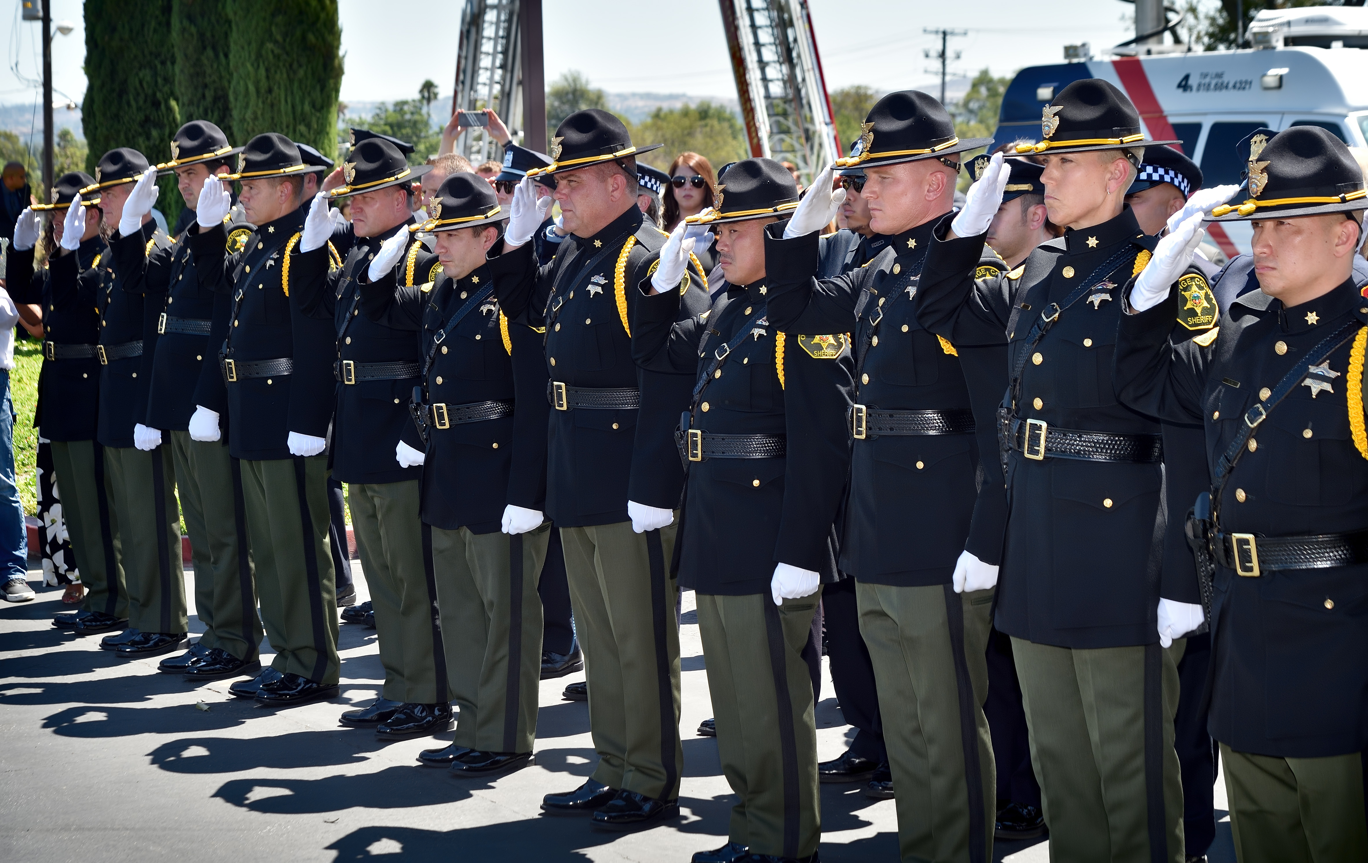Honor guards from the Orange County Sheriff’s Department salute as the body of CHP Officer Andre Moye Jr. is carried from the church at the conclusion of memorial services.Photo by Steven Georges/Behind the Badge