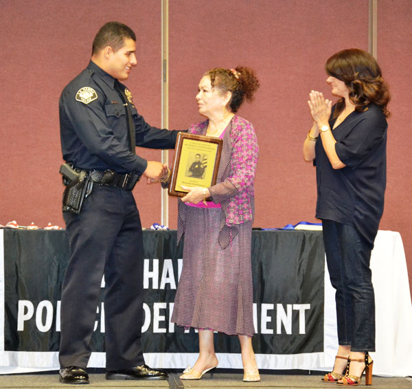 Officer Ricardo Rodriguez receives Osornio Award from Officer Osornio's mother and sister.