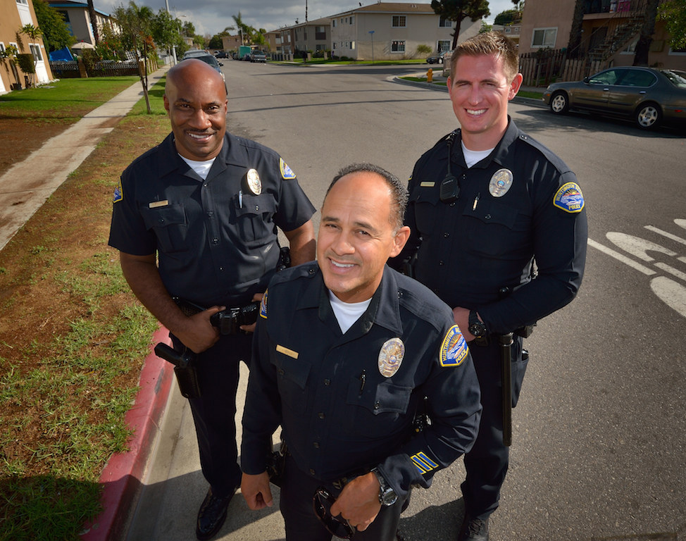 Huntington Beach Police Officers Bernard Atkins, left, Juan Munoz and officer in training, Sean McDonough in the Oak View neighborhood of Huntington Beach. The police department is launching a new effort to build community relationships and reduce gang violence in Oak View. Photo by Steven Georges/Behind the Badge OC