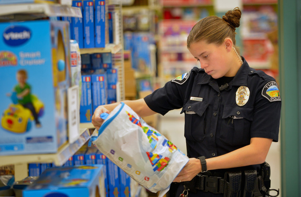 Tustin Police Officer Stephanie Kimosh checks out building blocks at the Toys R Us in Tustin as Tustin PD officers who recently graduated from Golden West Police Academy take their leftover funds from their dues and by $1,700 of toys for CHOC kids. Photo by Steven Georges/Behind the Badge OC