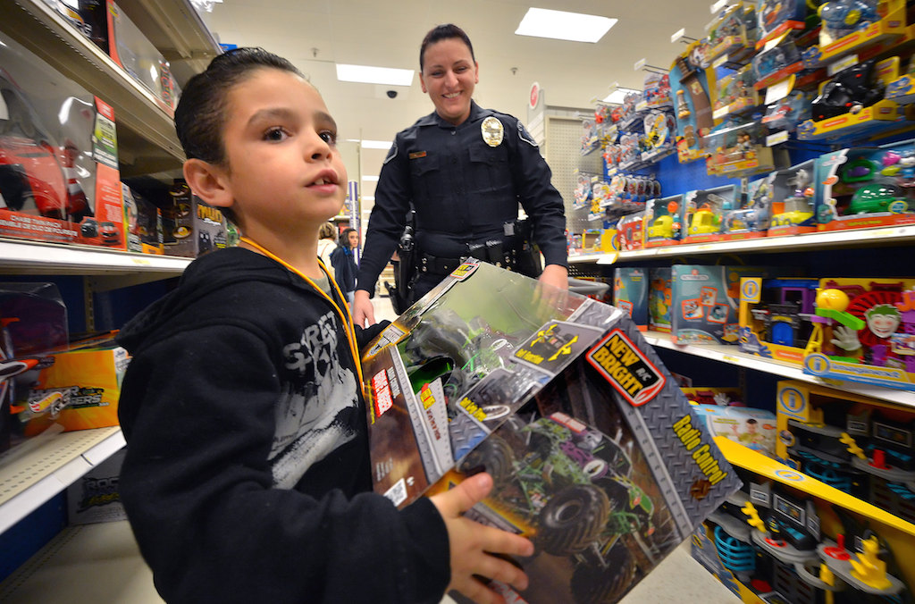Alexander Lozano checks out a radio controlled toy monster truck with Cypress Police Detective Deanna Alvis behind him during a special shopping spree with police officers at the Target Store in Cypress. Photo by Steven Georges/Behind the Badge OC