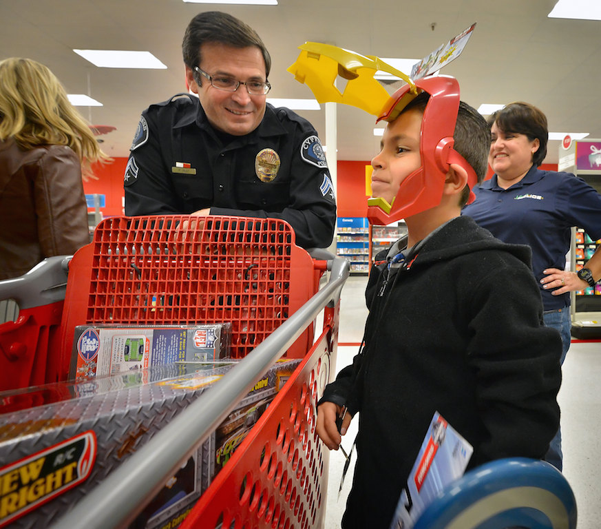 Cypress Police Detective Paul Ruiz helps Samuel Lozano shop for Christmas toys during a Shop with a Cop gathering at the Target store in Cypress. Photo by Steven Georges/Behind the Badge OC