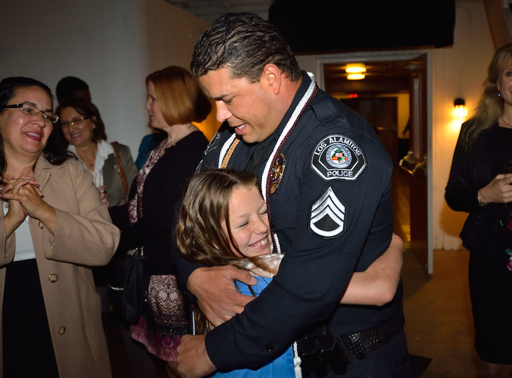 Ten-year-old Kyra Karrer gives her dad, Sgt. Chris Karrer of the Los Alamitos PD, a hug after he received his bachelor's degree from Columbia College during a small ceremony on board the Queen Mary. Photo by Steven Georges/Behind the Badge OC