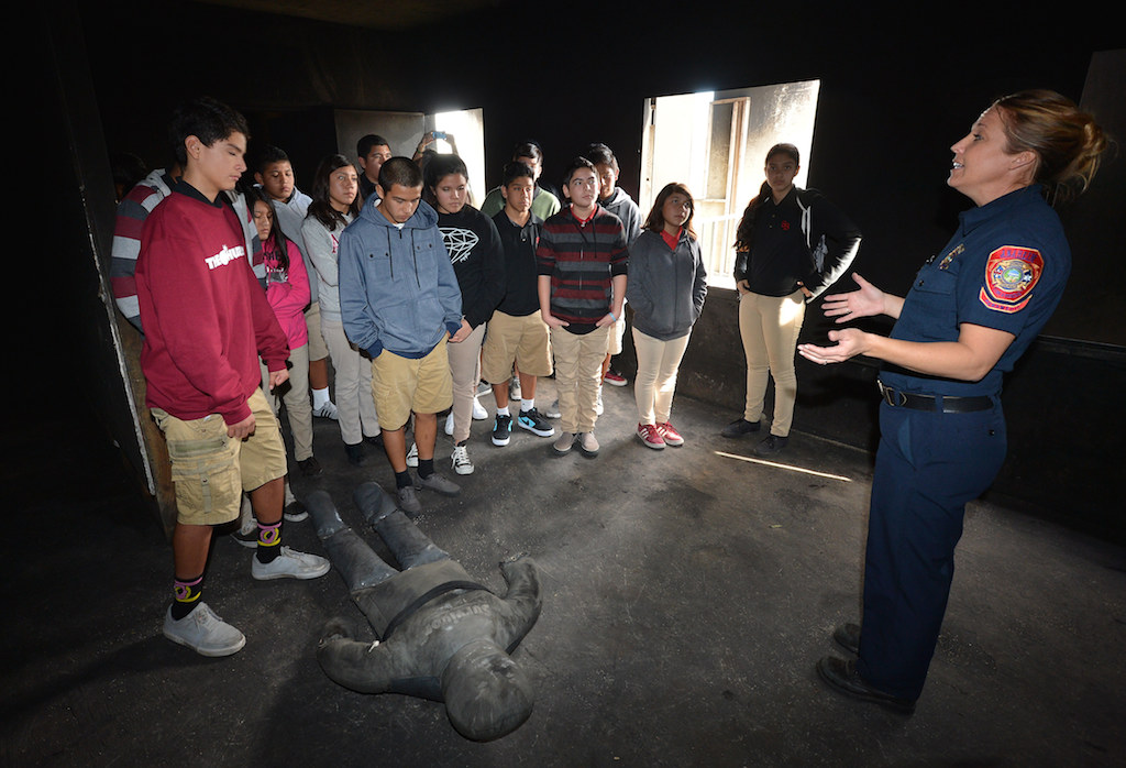 Anaheim Fire & Rescue Firefighter Lacee Valente takes a group of kids from Sycamore Jr. High inside the dark fire training tower, complete with one of the heavy training dummies, at the North Net Training Center in Anaheim. Photo by Steven Georges/Behind the Badge OC