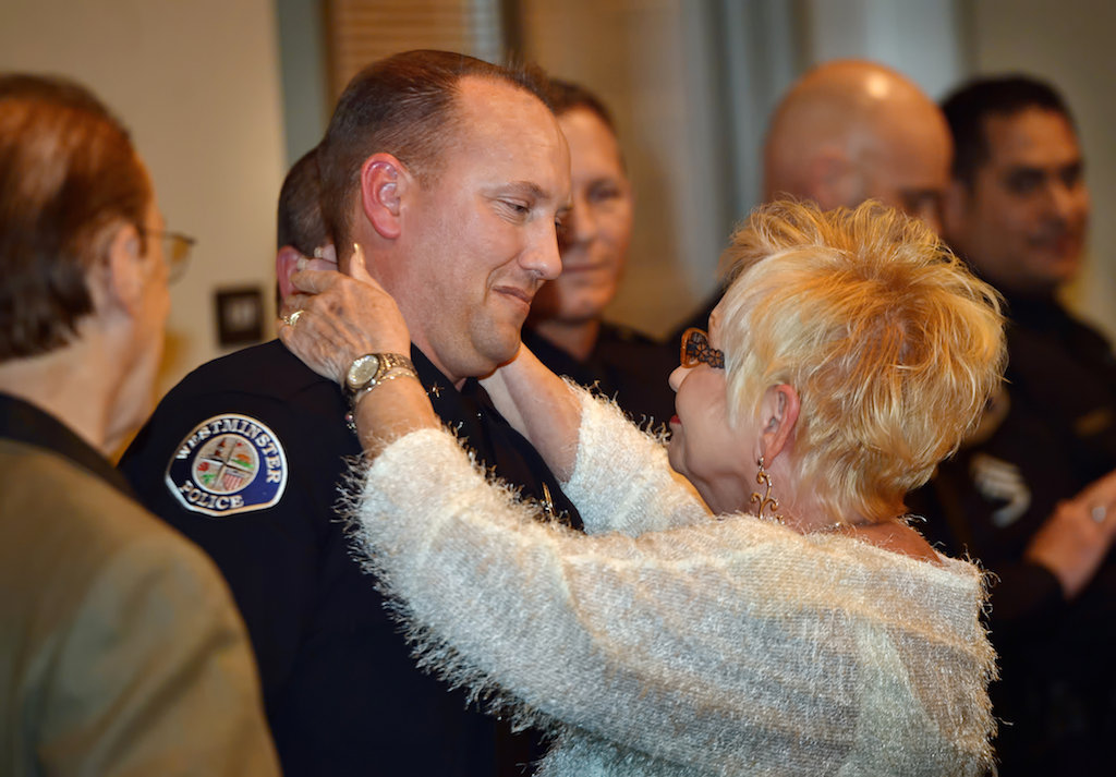 Cmdr. Cameron Knauerhaze is congratulated by his parents during a promotion ceremony at the Rose Center in Westminster. Photo by Steven Georges/Behind the Badge OC