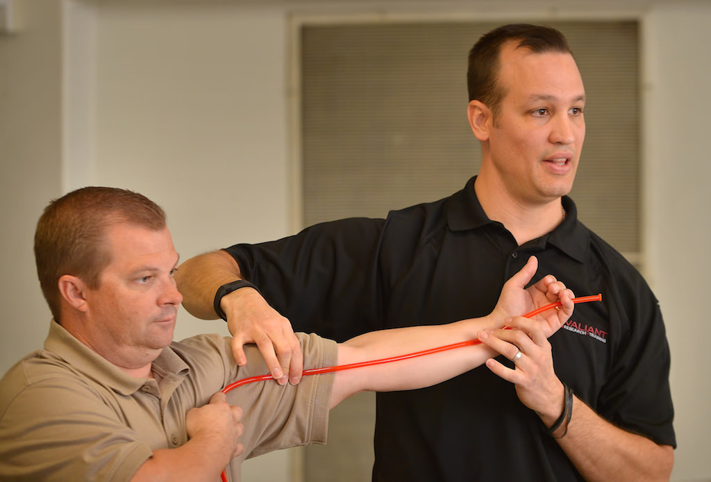 Todd Baldridge, MPD, EMT-P, left, and Joshua Bobko, MD, both of Valiant Research, demonstrate to a group of teachers from Westmont Elementary the location of the Breakerial autuary (sp?) during a first responder training seminar at their school in Westminster. Photo by Steven Georges/Behind the Badge OC