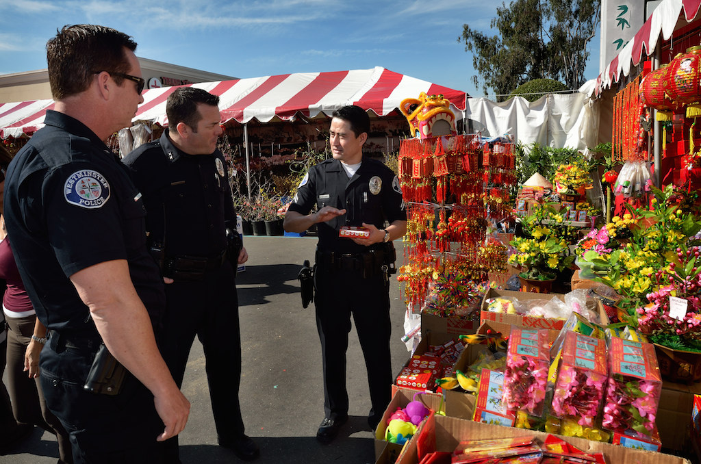 Westminster Police Officers Commander Bill Collins, left, Deputy Chief Dan Schoonmaker and Corporal Phuong Pham walk through the outdoor shops setup outside the Asian Garden Mall in Westminster’s Little Saigon. Photo by Steven Georges/Behind the Badge OC
