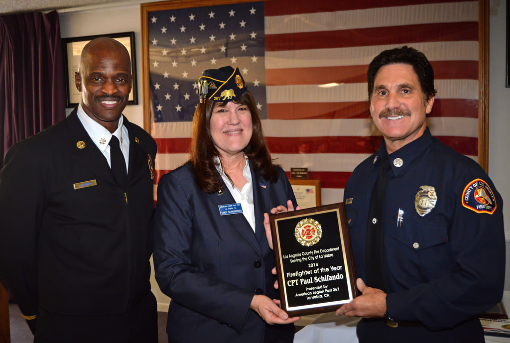 Cpt. Paul Schifando of the Los Angeles County Fire Department Serving the City of La Habra, right, receives the 2014 Firefighter of the Year award from Assistant Fire Chief Chris Jackson, left, and American Legion Post 267 Second Vice Commander Sandy Schneeberger during a ceremony at the Elks Lodge in La Habra. Schifando has been serving as a firefighter for 27 years.  I’ve dedicated my life to this job.  "Ever since I was  little boy, I wanted to be a firefighter," Shifando said. "I’m living my dream. I love going to work every single day and I love taking care of people . It’s a rewarding job."  Photo by Steven Georges/Behind the Badge OC