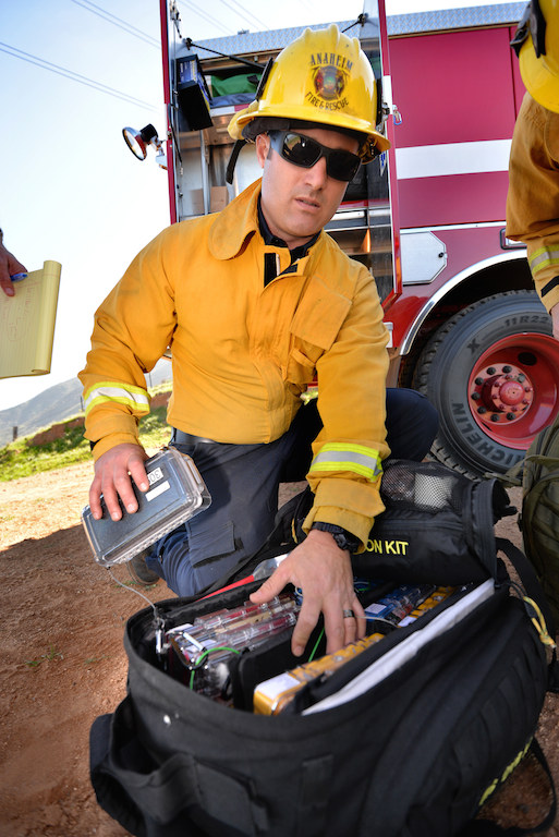 Engineer/Paramedic Chris Fulkerson of Anaheim Fire & Rescue, looks over the Isolation kit, part of the medical supplies stored on Engine 309, a type 3 engine. Photo by Steven Georges/Behind the Badge OC
