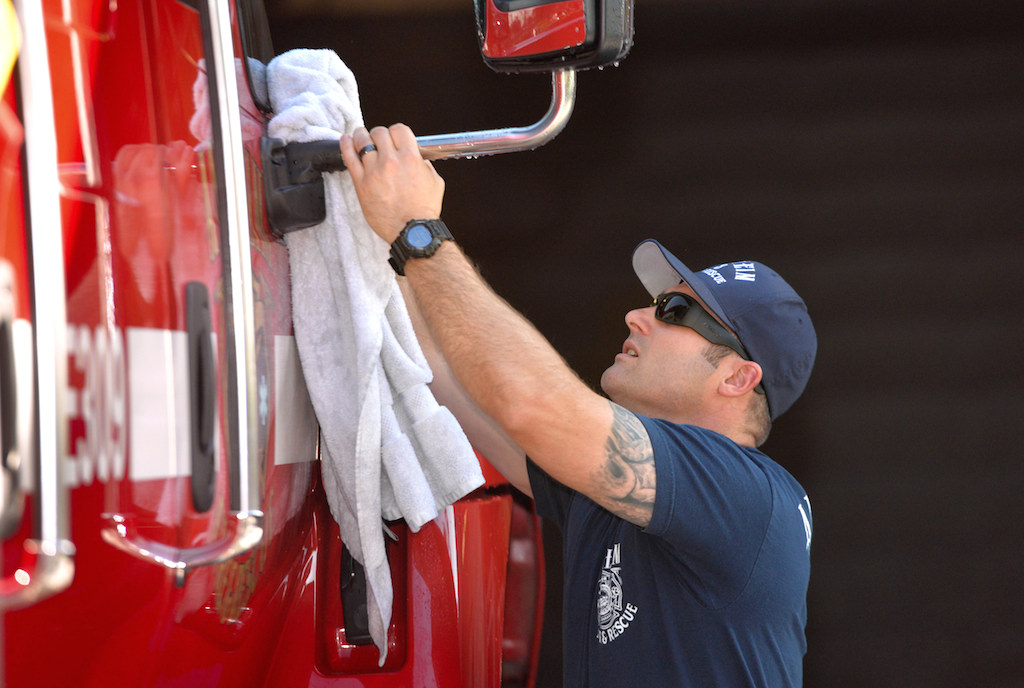 Chris Fulkerson, a firefighter engineer at Station 8, cleans a rig during a recent shit. Photo: Steven Georges