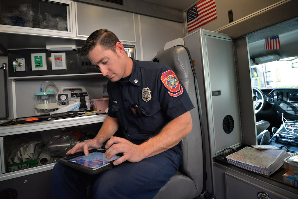 Capt. Michael Byard, a paramedic with Anaheim Fire & Rescue, logs in information from the scene of a current call on an iPad which automatically uploads the info to the department's database with the tablet’s built-in cellular connection. Photo by Steven Georges/Behind the Badge OC