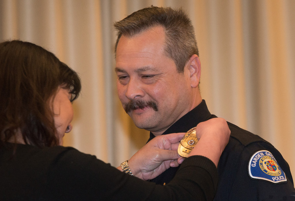Lt. Bob Bogue has new new badge pinned on him by his wife. Photo: Steven Georges