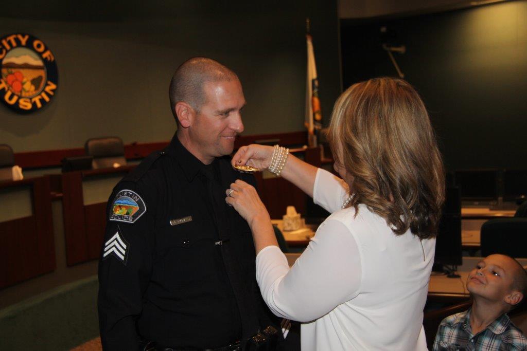 New Sergeant Matt Nunley has his badge pinned on by his wife. Photo by Police Services Officer Joseph Chiavatti