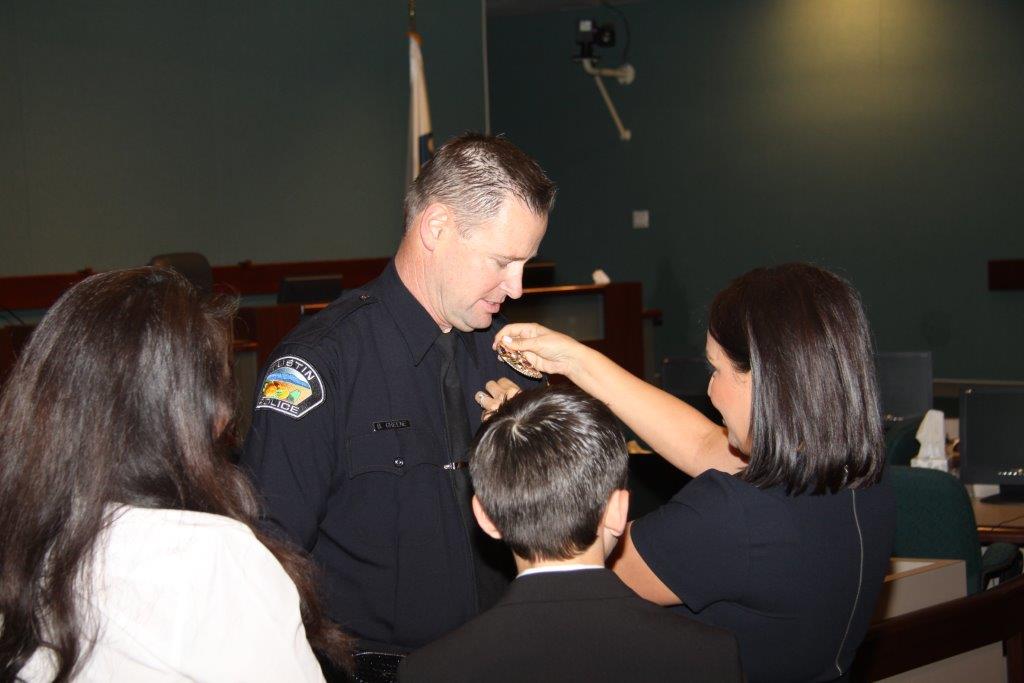 New Lieutenant Brian Greene gets his badge pinned on by his wife. Photo by Police Services Officer Joseph Chiavatti