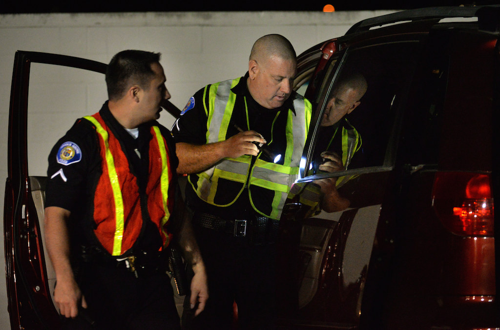 Garden Grove PD Officers Luis Payan, left, and Nathan Morton search a van driven by someone suspected of driving under the influence. Photo: Steven Georges