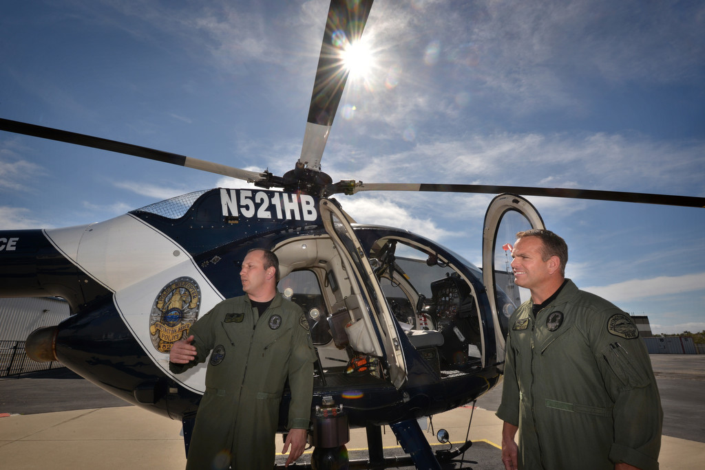 Huntington Beach Police Sgt. Chris Nesmith, left, and Police Officer Mark Wersching show off one of the police departments three helicopters at the Huntington Beach Police heliport after returning from a call. Photo by Steven Georges/Behind the Badge OC