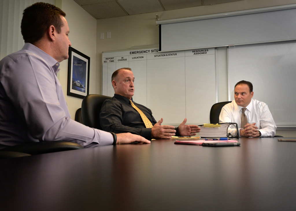 Capt. George Johnstone, left, Detective Cpl. Scott Irwin and Detective Craig Hentcy of the La Habra PD discuss a case.  Photo by Steven Georges/Behind the Badge OC