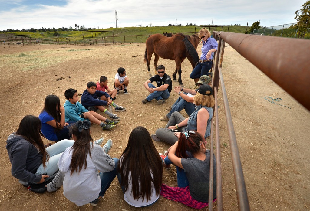 Officer Kurt Stoecklein of the Huntington Beach PD, a mounted officer himself, sits with advisors and kids from Oak View Elementary School as they talk about the troubles kids have and making good choices in life during a group discussion at the Huntington Central Park Equestrian Center. Photo by Steven Georges/Behind the Badge OC