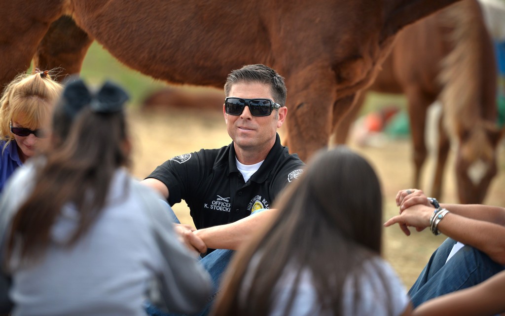 Officer Kurt Stoecklein of the Huntington Beach PD, a mounted officer himself, listens to kids as they talk about peer pressure and the choices they make in life during a group discussion at the Huntington Central Park Equestrian Center. Photo by Steven Georges/Behind the Badge OC