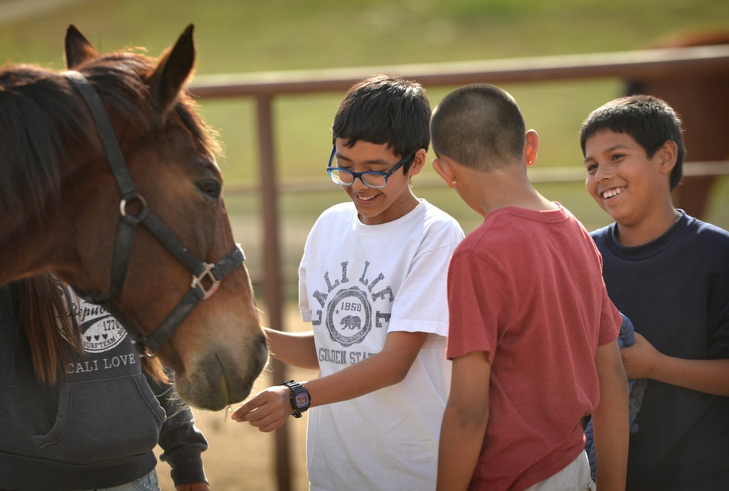 Kids take turns to interact with one of the horses at Huntington Central Park Equestrian Center. The afternoon is part of a 10-week program for students from Oak View Elementary School sponsored by the Huntington Beach PD and the Rainbow Environmental Services. Photo by Steven Georges/Behind the Badge OC