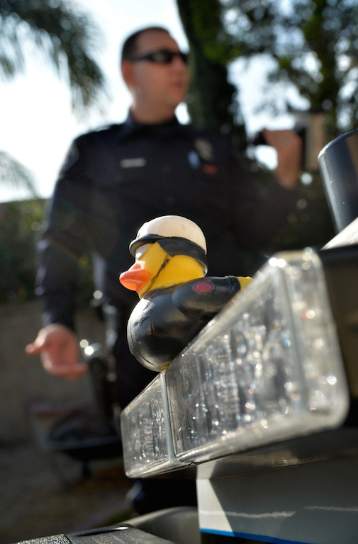 A duck in a police motor officer uniform that his wife received from their baby shower sits on the back of Motor Officer Kyle Baas’ Fullerton PD motorcycle. He keeps it there “to show people we’re human . . . It makes people smile and let’s them know we’re people too.” Photo by Steven Georges/Behind the Badge OC