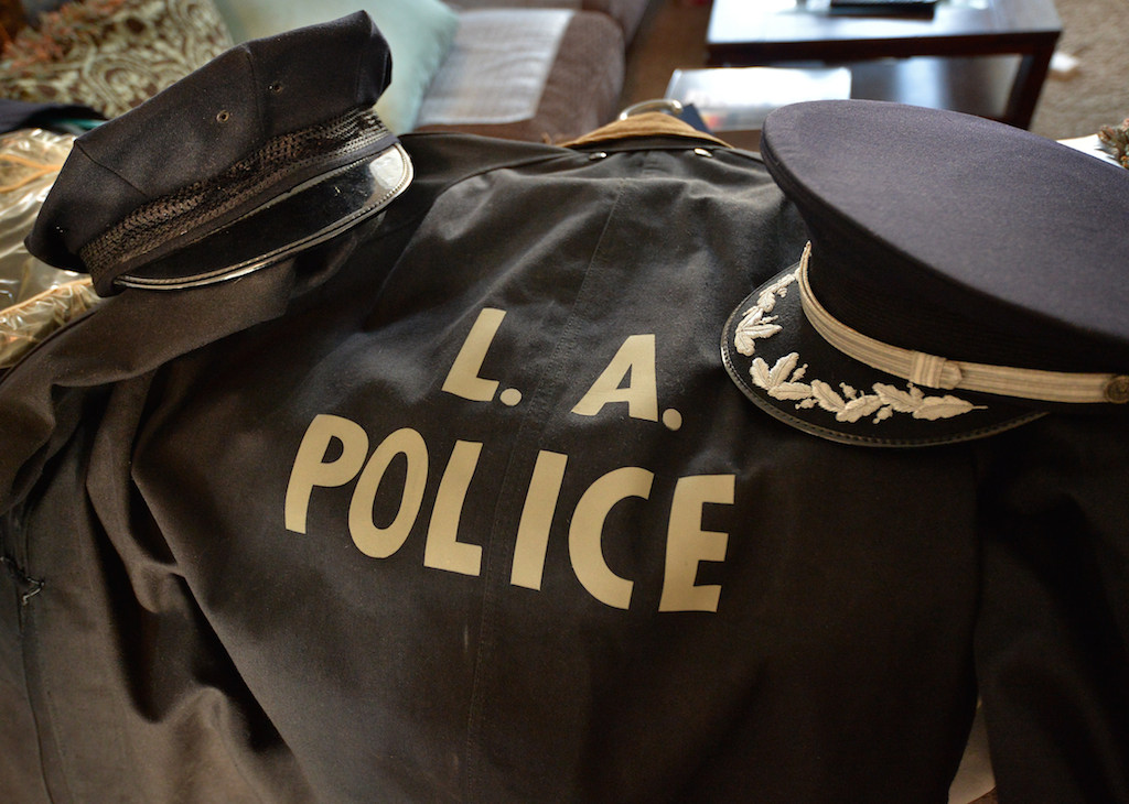 Kyle Baas kept the uniforms of his grandfather, former Los Angeles PD Deputy Chief John McAllister. On the left is the hat he wore when he was a motor officer, before the days of helmets, around 1949-1956. On the left is his Deputy Chief dress hat. The shields unfortunately had to be removed from the hats when he retired. Photo by Steven Georges/Behind the Badge OC