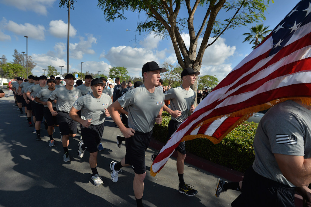 John Yergler, behind the flag, starts a 3-mile run with his class at the Orange County Sheriff's Regional Training Academy in Tustin on the last day of training before graduation. Yergler will be starting work at the Garden Grove Police Department. Photo by Steven Georges/Behind the Badge OC
