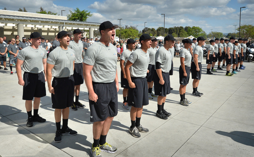 Police cadets stand at attention before being dismissed as their family and friends watch behind them at the Orange County Sheriff's Regional Training Academy in Tustin on the last day of training before graduation. Photo by Steven Georges/Behind the Badge OC