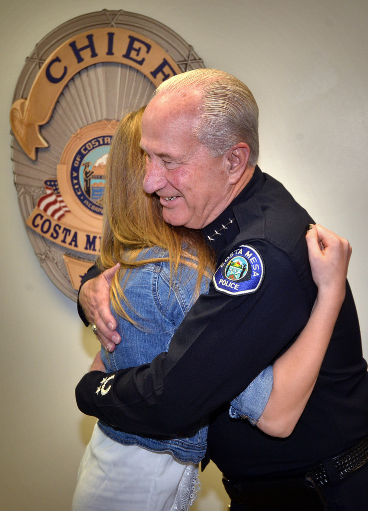 Interim Police Chief Ron Lowenberg of the Costa Mesa PD gets a hug from 15-year-old Haley Farnsworth who came to the police department to thank them for saving her from jumping from a freeway overpass about year ago. Photo by Steven Georges/Behind the Badge OC