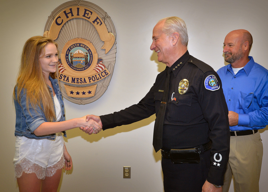 Haley Farnsworth, 15, thanks Interim Costa Mesa Police Chief Ron Lowenberg and Sgt. Tom Starn, now retired, right, for saving her from jumping from a freeway overpass about year ago. Photo by Steven Georges/Behind the Badge OC