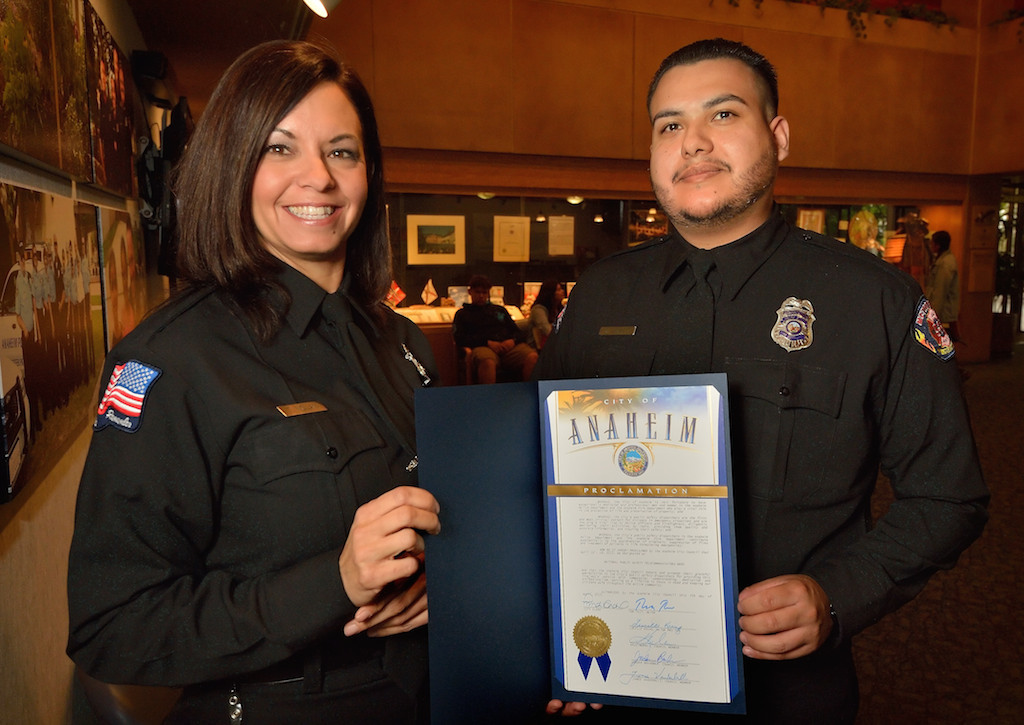 Lead Dispatcher Tracy Nolan, left, and Fire Dispatcher II Steven Perez of Metro Cities Fire Authority hold a proclamation by the Anaheim City Council designating April 12-18, 2015 National Public Safety Telecommunicators Week. Photo by Steven Georges/Behind the Badge OC