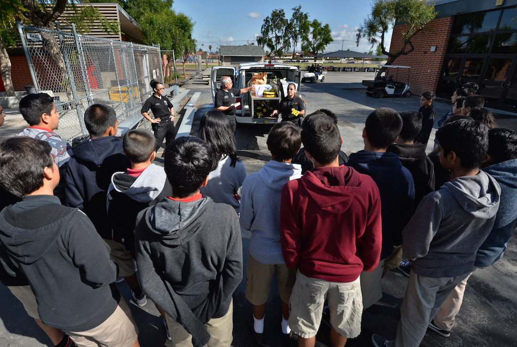Anaheim PD Forensic Specialist Jeannette Torres, left, Supervisor Mark Sveinson and Cristy Medina talk to kids from Sycamore Junior High as they show them the tools they use at a crime scenes. Photo by Steven Georges/Behind the Badge OC
