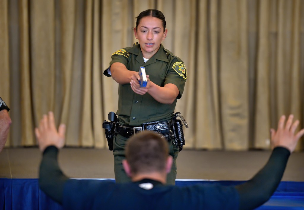 Orange County Sheriff Recruit Margarita Alatore orders a suspect to the ground with a simulated blue gun after wrestling with him during an exhausting Will to Survive test at the OC Sheriff Training Academy in Tustin. Photo by Steven Georges/Behind the Badge OC
