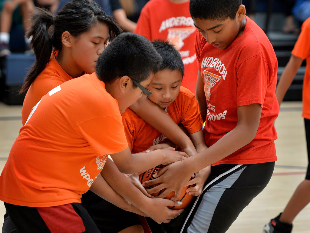 Honey Nguyen, left, Eduardo Zarate and Kyle Pham of team Webber scramble to keep the ball from Henry Booth of team Anderson during the Hoops Basketball League championship game sponsored by the Westminster Police Officer's Association. Photo by Steven Georges/Behind the Badge OC