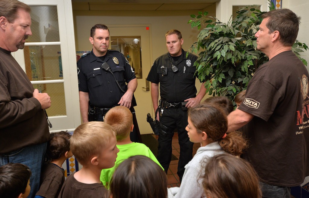 Sgt. John Ema, left, and Officer Jonathan Miller of the Fullerton PD talk to kids from Adventure Guides as they start their tour of the Fullerton Police Department. Photo by Steven Georges/Behind the Badge OC