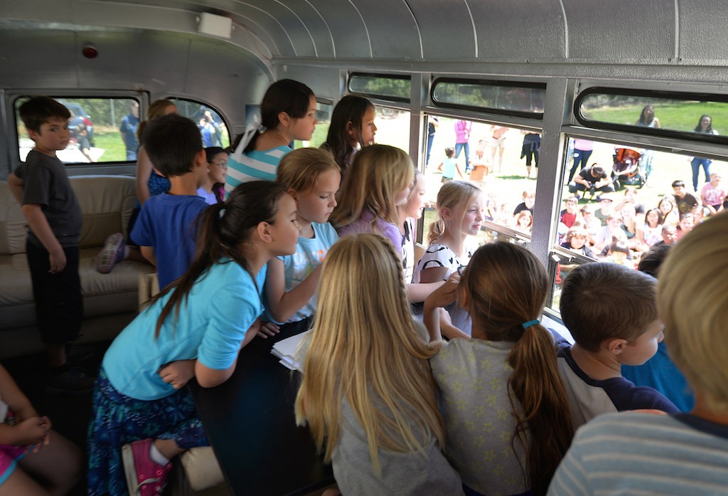 Kids from Rolling Hills Elementary School in Fullerton watch a Team Kids assembly from in side a bus being used as a backdrop for the assembly. Photo by Steven Georges/Behind the Badge OC