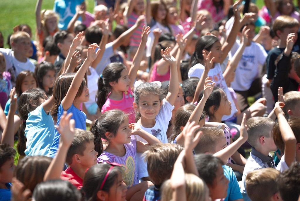 Kids from Rolling Hills Elementary School raise their hands to volunteer as members of the Fullerton Police and Fire Departments visit the school during a Team Kids assembly. Photo by Steven Georges/Behind the Badge OC