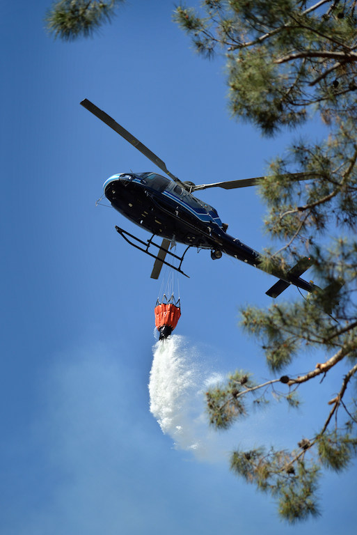 A helicopter from Anaheim PD drops water on a vegetation fire that broke out in the Brea Dam Recreation Area Saturday afternoon threatening homes in the Fullerton area. Photo by Steven Georges/Behind the Badge OC