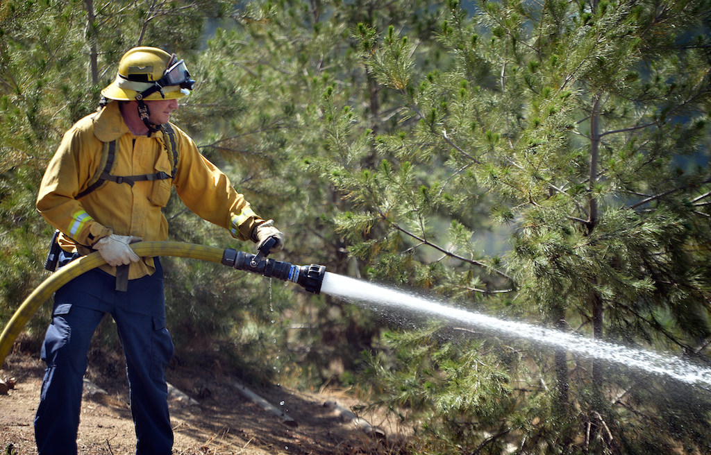 Gamble of Anaheim Fire & Rescue lays water down on a vegetation fire that broke out in the Brea Dam Recreation Area Saturday afternoon. Photo by Steven Georges/Behind the Badge OC
