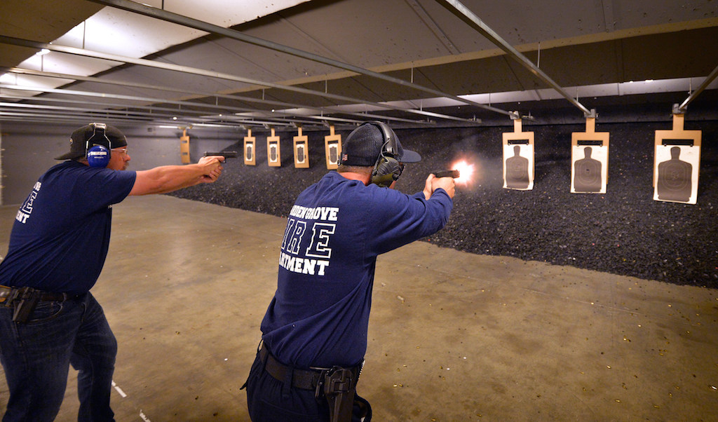 Garden Grove Fire Arson Investigators Mike Jacobs, left, and Bill Strohm fires with Glock 45 caliber handguns during close range certification training at Field Time Target & Training shooting range in Stanton. Behind the targets are ground rubber chunks and armor plating with a bullet trap behind the rubber. Photo by Steven Georges/Behind the Badge OC