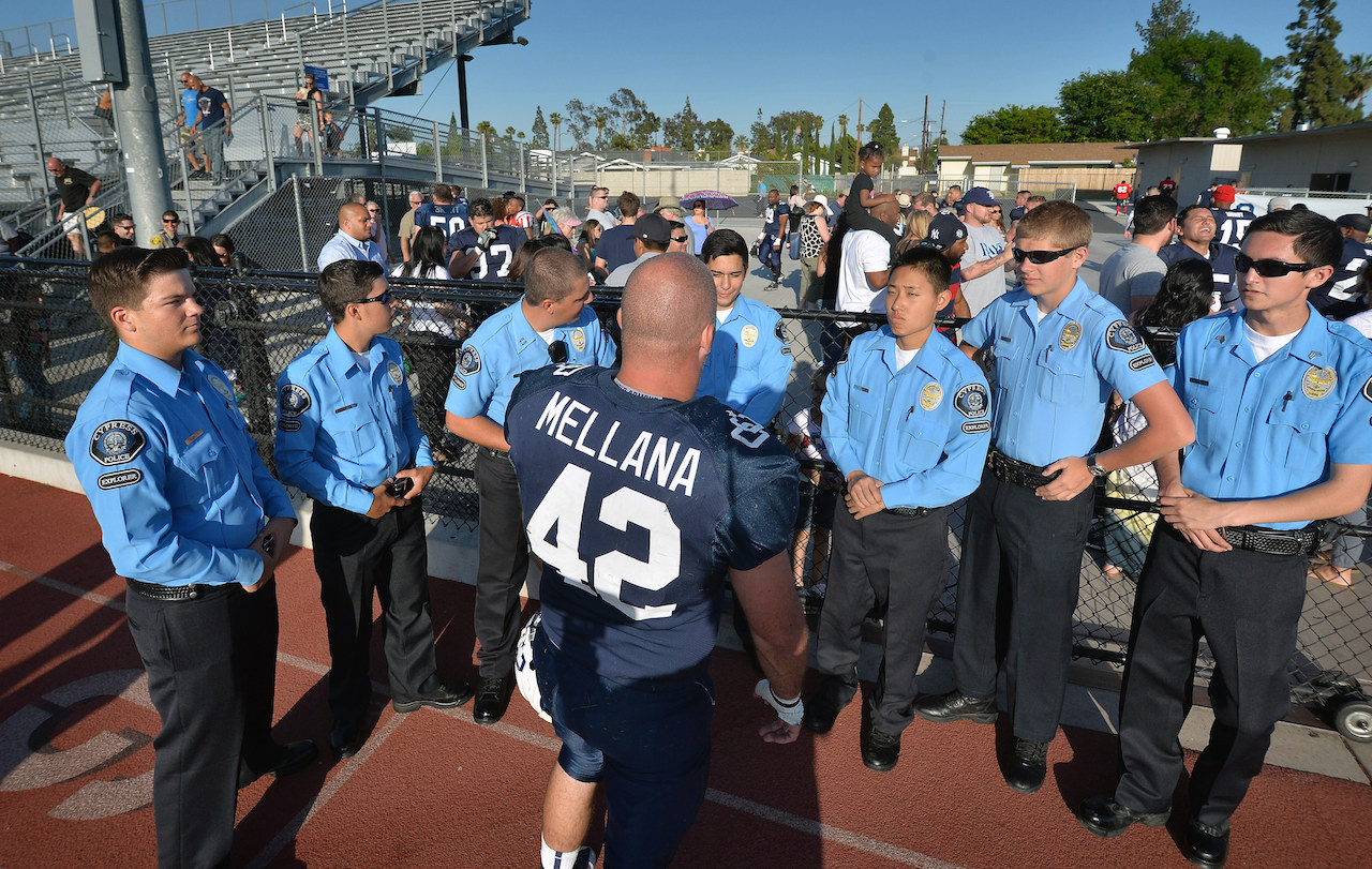OC Lawmen Tommy Mellana (42) of Cypress PD gets together with Cypress Explorers at the conclusion of Freedom Bowl II at Bradford Stadium raising money for Special Olympics Southern California. Photo by Steven Georges/Behind the Badge OC