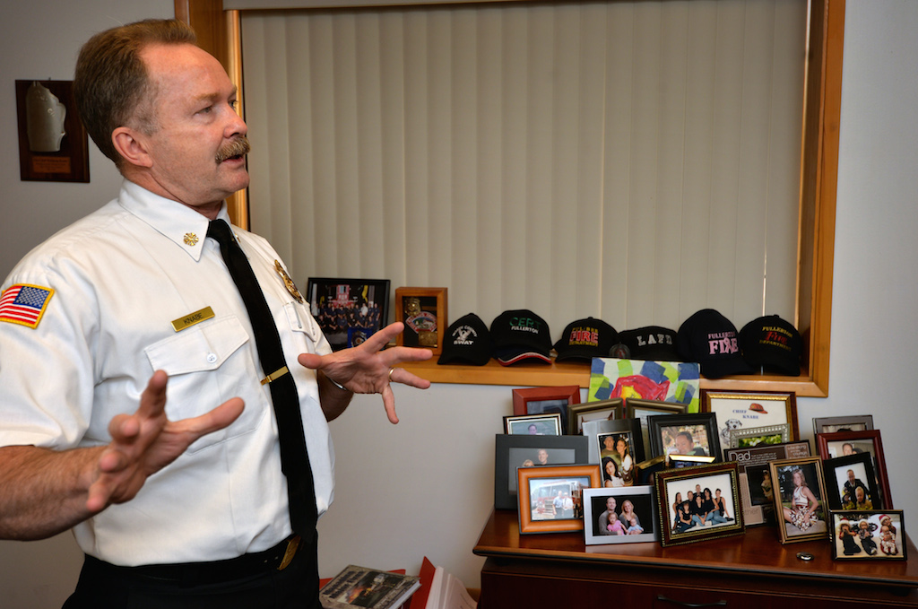 Fullerton Fire Chief Wolfgang Knabe in his office that displays photos of his family and the many hats of his long career. Photo by Steven Georges/Behind the Badge OC