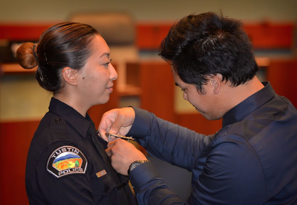 Tustin Officer Yun “Ivy” Zhao has her badge pinned to her by her boyfriend Nate Rosales during a Tustin PD swearing in ceremony. Photo by Steven Georges/Behind the Badge OC
