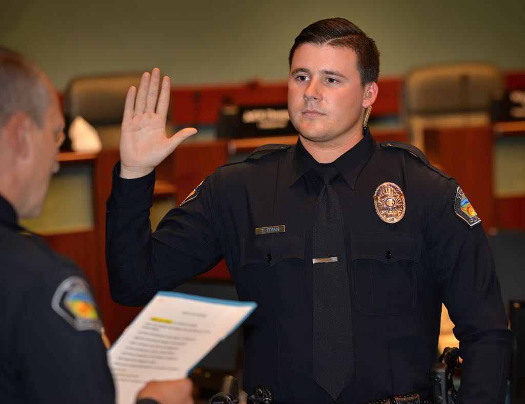 Taylor Ryan, who originally pursued a career as a pastor and later graduated from Golden West Police Academy, is sworn in as a new Tustin Police Officer by Tustin Police Chief Charles Celano, left. Photo by Steven Georges/Behind the Badge OC