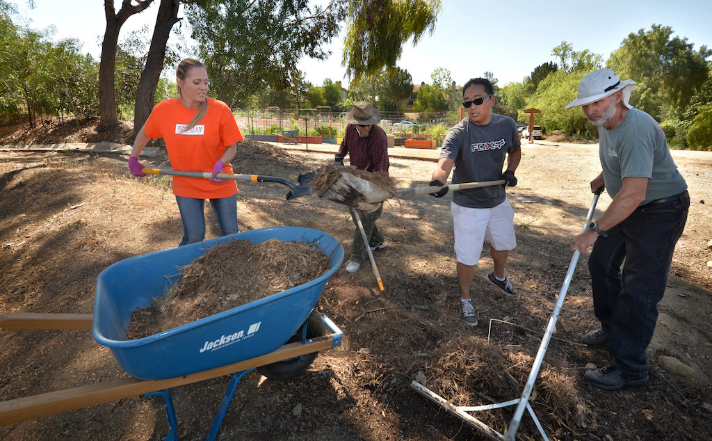Volunteers Kellie Thomas of Home Depot, left, Bill Kelly, Fred Chun and Mike Douglas work to clear a lot next to Anaheim Fire Station 10 before installing a FireSafe and drought resistant demonstration garden. Douglas wanted to volunteer after being rescued by Anaheim firefighters from a motorcycle accident in December of 2013. (and a medical aid situation in 2012) “I wanted to give back to the fire department for doing such an outstanding job,” said Douglas. Photo by Steven Georges/Behind the Badge OC