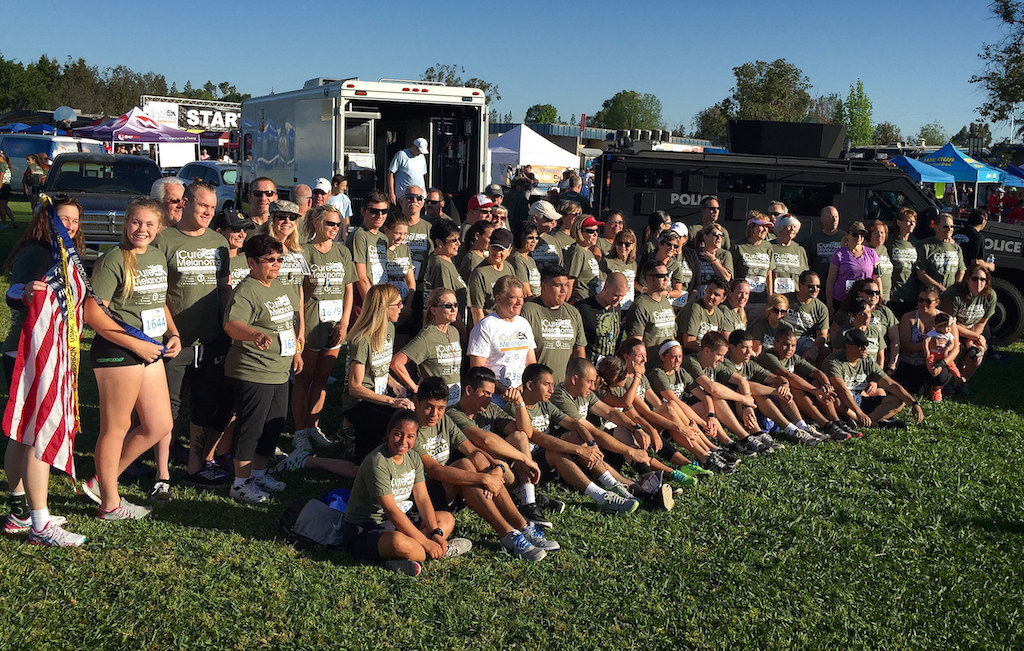 Team Mac, friends and family of FPD Sgt. Mike MacDonald who passed away from melanoma cancer in 2009 and his wife Karen MacDonald, gather in front of Fullerton PD SWAT truck before the start of the iCureMelanoma 5k at Laguna Rd. School Park in Fullerton to raise money funding research for a cure for Melanoma Cancer. Photo by Steven Georges/Behind the Badge OC