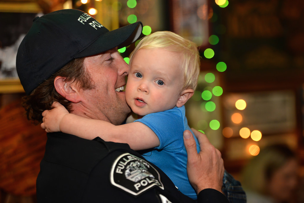 Cpl. Joel Craft of the Fullerton PD gets a hug from his 14-month-old son Nolan Craft at Heroes Bar and Grill during the Tip-A-Cop fundraiser benefiting the Athletes of Special Olympics Orange County. Photo by Steven Georges/Behind the Badge OC
