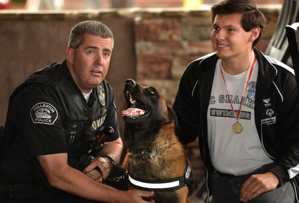 Fullerton PD Officer Tim Haid, left, with his K-9 partner Rotor and Christian Valdez, last year’s Special Olympics gold medal Athlete in the butterfly, at Heroes Bar and Grill during the Tip-A-Cop fundraiser benefiting the Athletes of Special Olympics Orange County. Photo by Steven Georges/Behind the Badge OC
