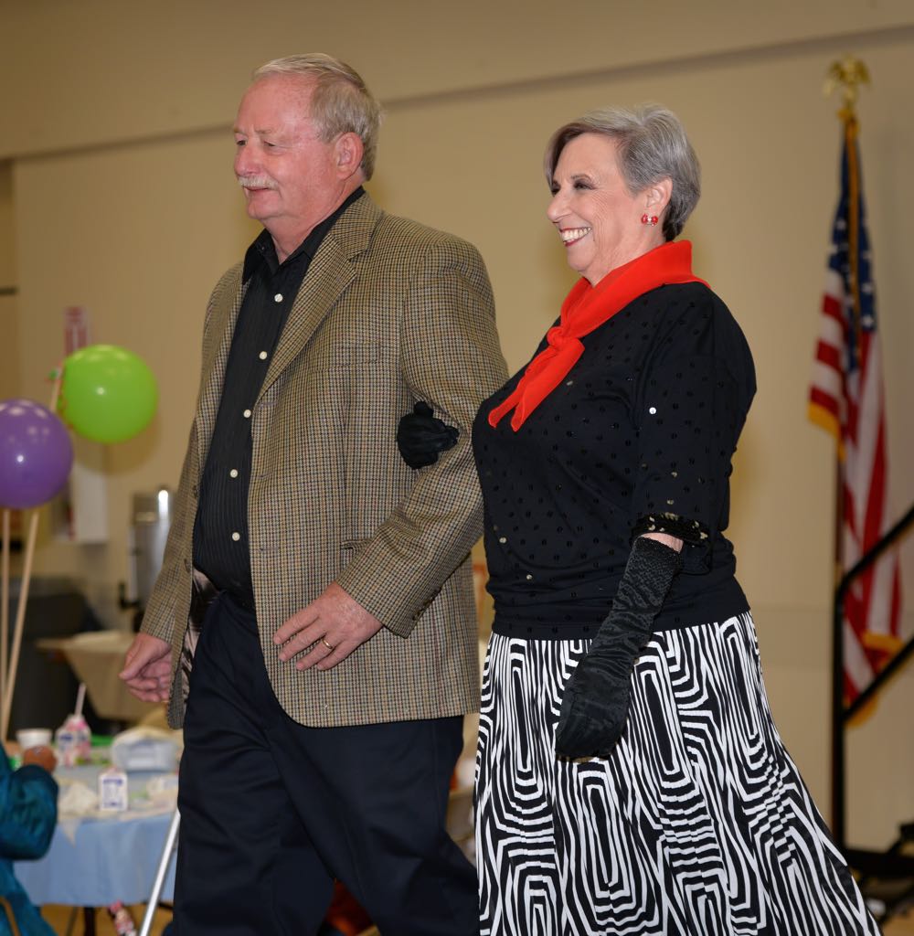 Tustin PD Master Reserve Officer George Vallevieni and Bonnie Squier make their way down the runway during the Mother’s Day Luncheon & Fashion Show at the Tustin Area Senior Center. Photo by Steven Georges/Behind the Badge OC