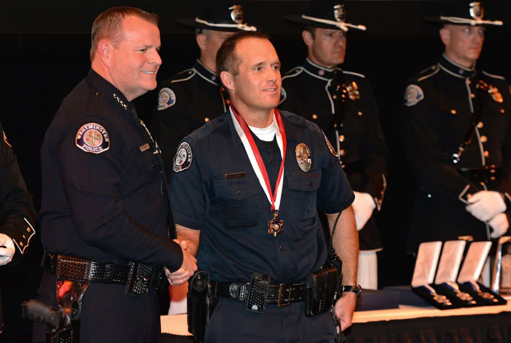Officer Tim Walker receives the Medal of Merit from Chief Kevin Baker during the 2014 Westminster PD Awards Ceremony. Photo by Steven Georges/Behind the Badge OC